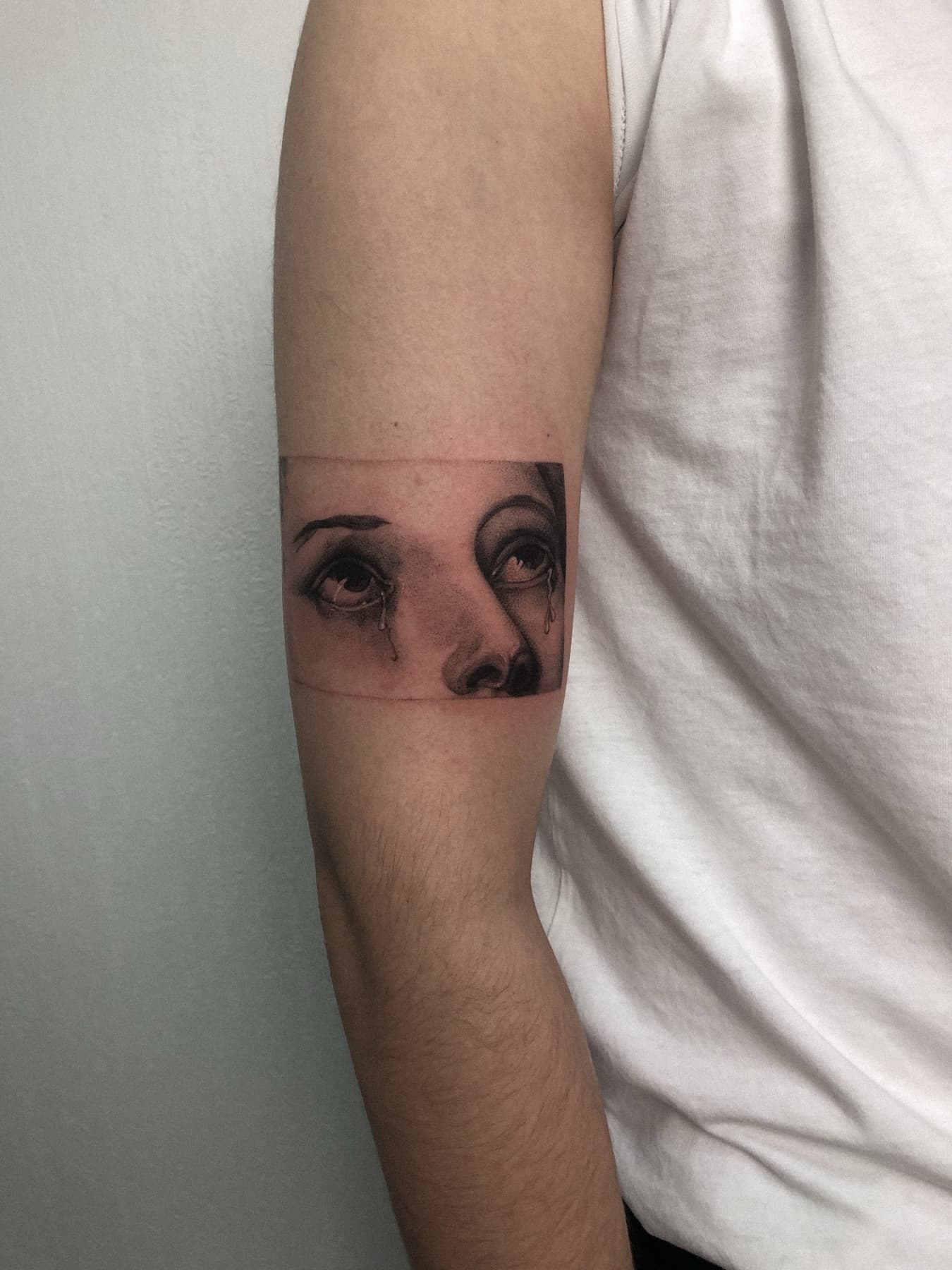Micro-Realism-Tattoo eines weinenden Auges am Oberarm
