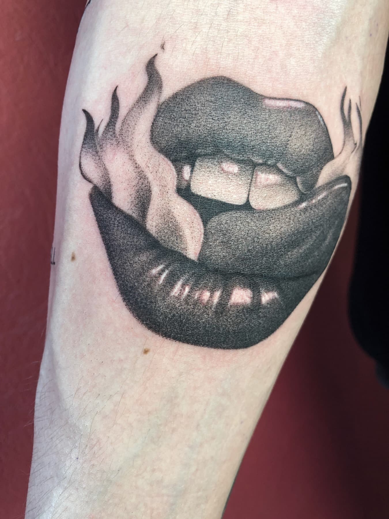 Illustratives Tattoo von Lippen mit Rauch am Unterarm