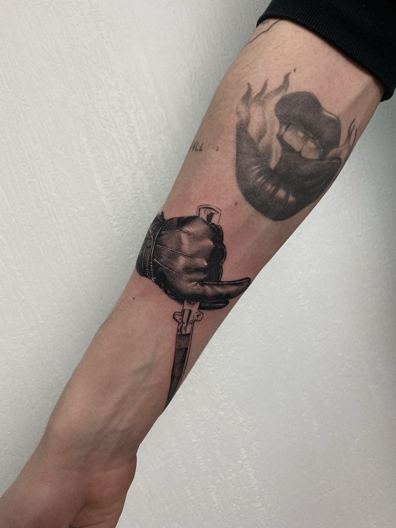 Illustratives Tattoo einer Hand mit Dolch