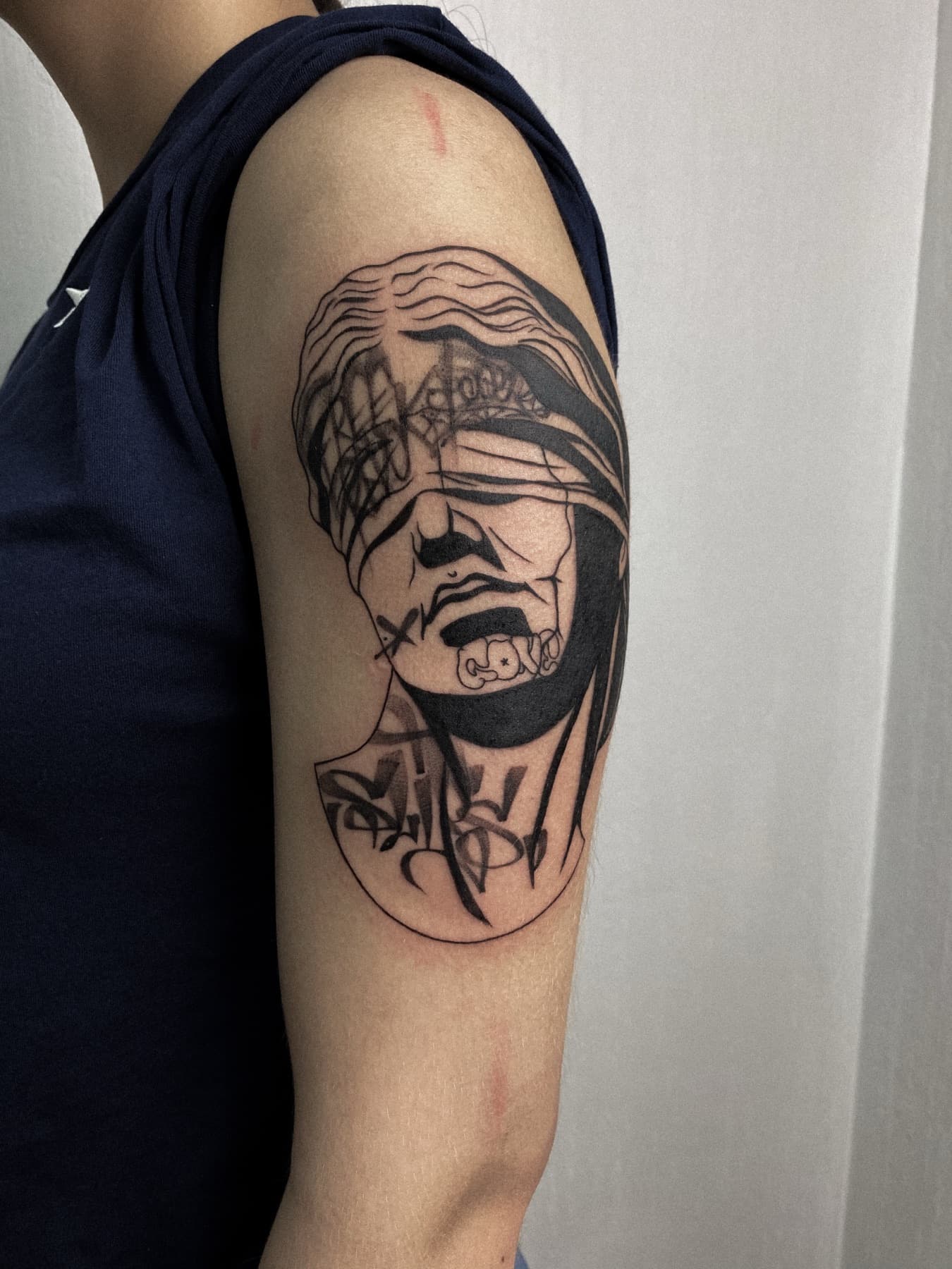 Grafisches Porträt-Tattoo am Oberarm
