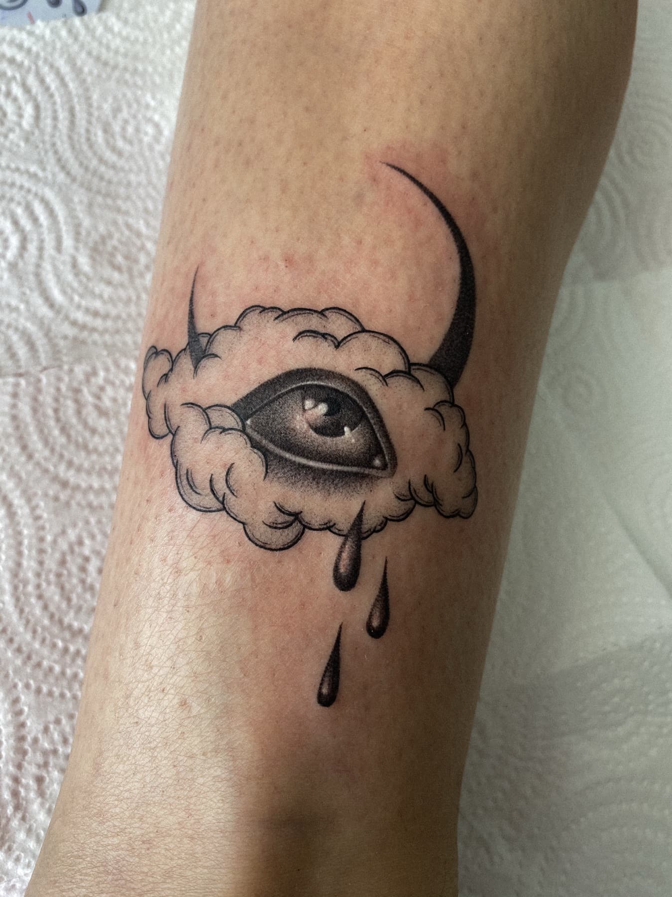 Fine-Line-Tattoo eines Auges mit Mondsichel