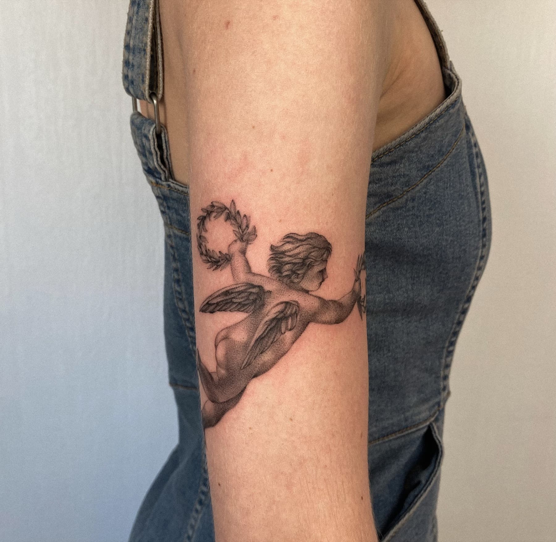 Illustratives Engel-Tattoo mit Lorbeerkranz