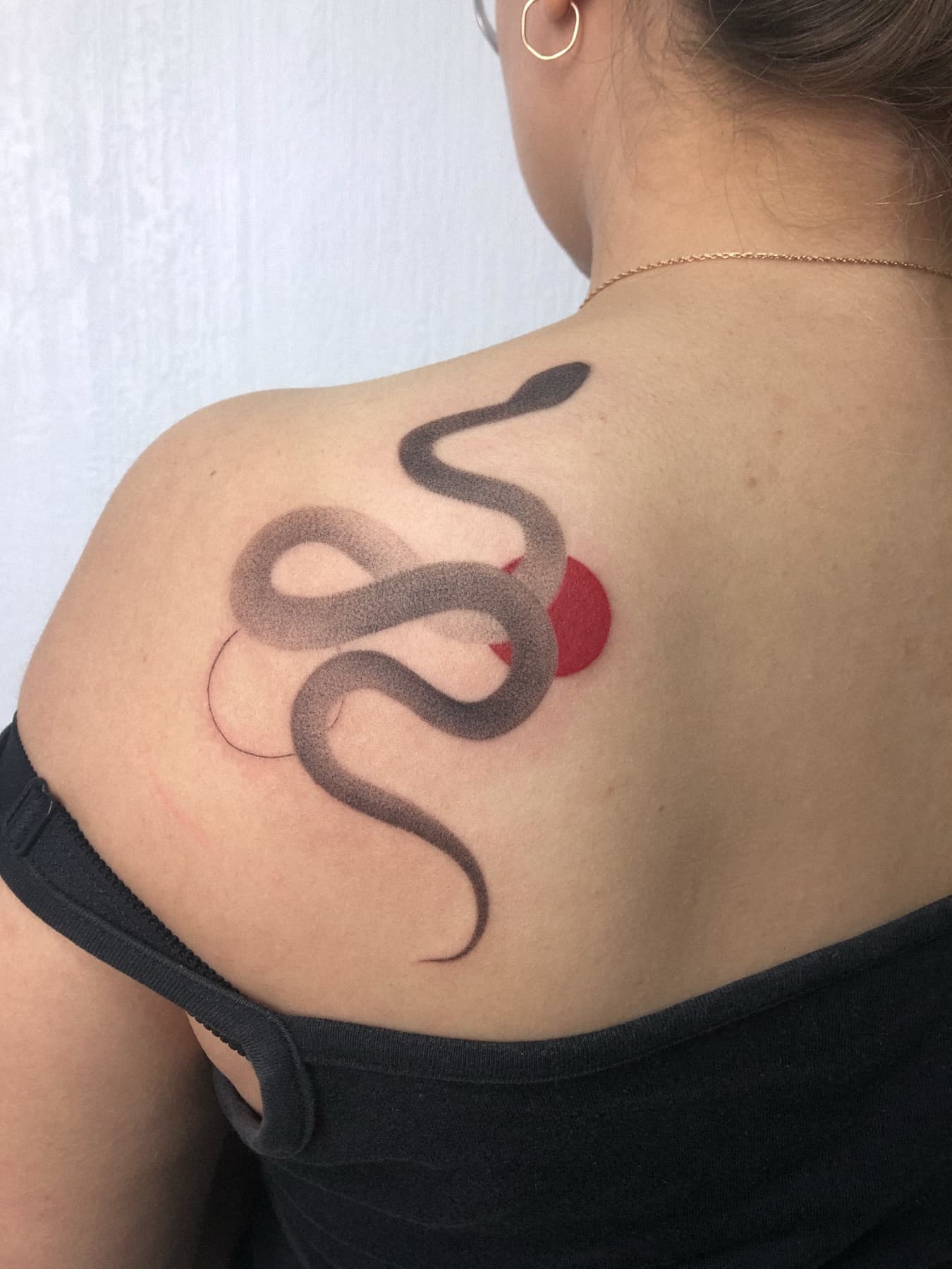 Fine-Line-Schlangen-Tattoo mit rotem Sonnenakzent